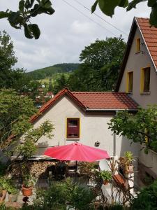 a red umbrella sitting in front of a house at Ferienhaus Am Kirchberg in Kurort Steinbach-Hallenberg