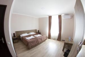 a bedroom with a bed and a large window at Hotel Beni in Akhaltsikhe