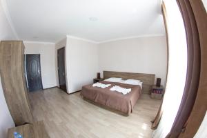 a bedroom with a bed and a mirror at Hotel Beni in Akhaltsikhe