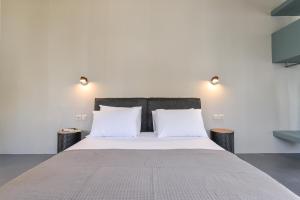 a bedroom with a large bed with two night stands at Agreli hora in Tinos Town