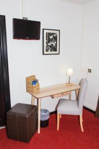 - un bureau avec une chaise et une table avec un haut-parleur dans l'établissement Hôtel Le Verger De Bischwiller, à Bischwiller