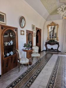 ジョヴィナッツォにあるB&B villa Mariaのテーブルと椅子と鏡のあるリビングルーム