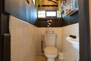 a small bathroom with a toilet and a sink at 沖縄古民家お宿ななつぼし Okinawa Traditional House Nanatsuboshi in Naha +41 photos