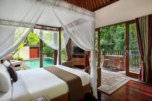 a bedroom with a bed and a balcony with a pool at Gending Kedis Luxury Villas & Spa Estate in Jimbaran +99 photos