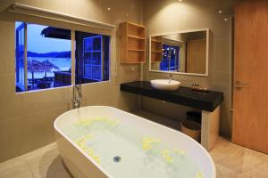 a bath room with a bath tub and a large mirror at Bubu Resort in Perhentian Islands
