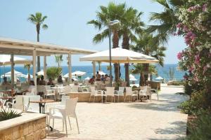 a restaurant with chairs and umbrellas on the beach at Villa Samantha in Paphos