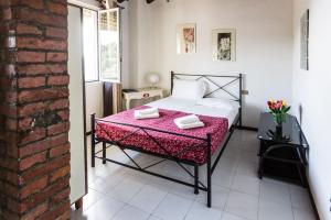 a bedroom with a bed with a pink blanket at Fattoria Cristina - Fenice in Castelnuovo Magra