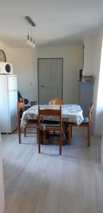 1 dormitorio con 1 cama, mesa y sillas en Appartement La Tour, en Embrun