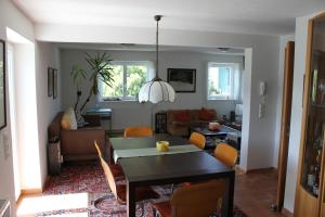 a dining room and living room with a table and chairs at Ferienwohnung mit Panoramablick in Viktorsberg