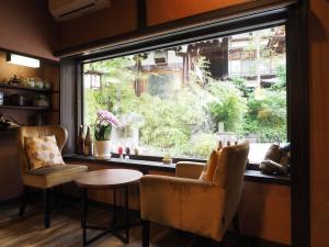 a window in a room with two chairs and a table at Ikariya Ryokan in Yamanouchi