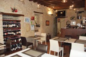 a restaurant with tables and chairs and wine bottles at Oro Rosso Hotel Ristorante in Montefalco