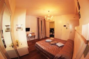 a bedroom with a bed and a chandelier at Oro Rosso Hotel Ristorante in Montefalco