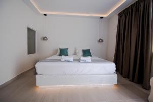 a bedroom with a large white bed with green pillows at Sea Wave Hotel in Perissa