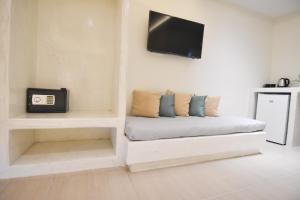 a room with a couch with a tv on a wall at Sea Wave Hotel in Perissa