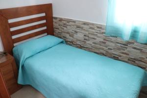 2 camas individuales en un dormitorio con una pared de ladrillo en Apartamento para 3 en el centro, en Conil de la Frontera