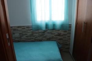 sypialnia z łóżkiem i oknem z niebieskimi zasłonami w obiekcie Apartamento para 3 en el centro w mieście Conil de la Frontera +5 zdjęć