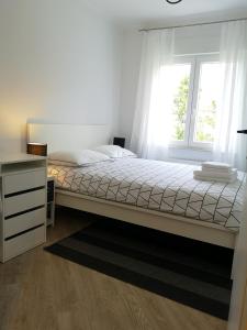 a bedroom with a bed and a dresser and a window at Apartment Gervais Rijeka in Rijeka