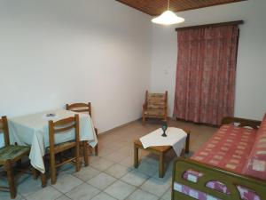 a dining room with a table and chairs and a couch at Apartmets Sunwaves in Kerveli