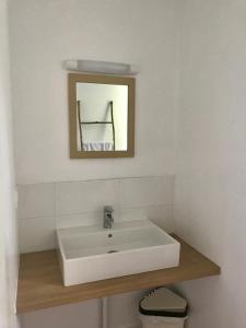 La salle de bains est pourvue d'un lavabo blanc et d'un miroir. dans l'établissement Centre de Vacances CPCV Normandie à 50 metres de la plage de Houlgate, à Houlgate