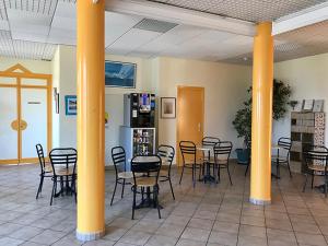 une pièce avec des tables et des chaises dans un bâtiment dans l'établissement Centre de Vacances CPCV Normandie à 50 metres de la plage de Houlgate, à Houlgate 18 autres photos