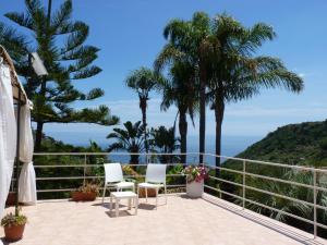 un balcone con 2 sedie e palme di holidaysora Taormina - il giardino di Graziella a Taormina