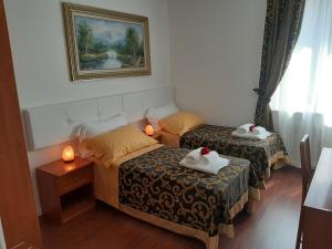 Dos camas en una habitación con dos velas. en Carpe Diem Ancona, en Ancona