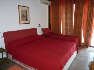 una camera con letto rosso e finestra di holidaysora Taormina - il giardino di Graziella a Taormina