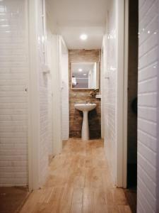a white bathroom with a sink and a mirror at White House Hostel in Bangkok