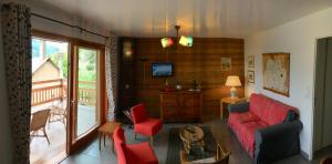 a living room with a red couch and red chairs at Chalet de l'Orceyrette, idéal pour un couple ou famille avec 2 enfants in Briançon