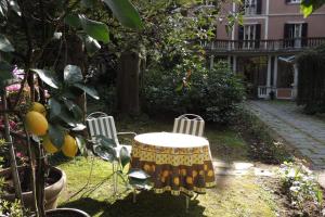 een tafel en twee stoelen in een tuin bij B&B Villa Margherita in Lesa