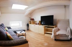ein Wohnzimmer mit einem Sofa und einem Flachbild-TV in der Unterkunft Apartment L&M in Piran