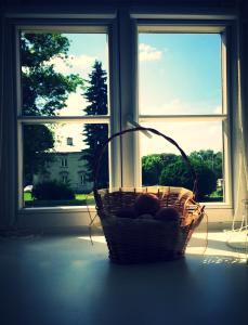 a basket of fruit sitting in front of a window at M&M apartamenty in Zamość