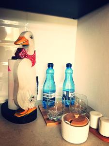 a duck statue sitting on a counter with wine glasses at M&M apartamenty in Zamość