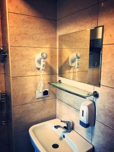 a bathroom with a sink and a mirror at M&M apartamenty in Zamość