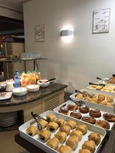 uma cozinha com várias bandejas de donuts num balcão em Hostal Bonavista em Calella