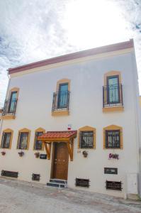 a white building with windows and a door at Kasbah Shirin in Selçuk