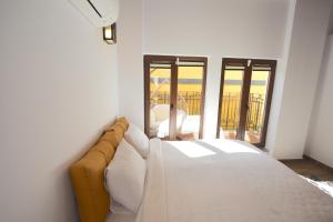 a bedroom with a bed and a view of a balcony at Kasbah Shirin in Selçuk