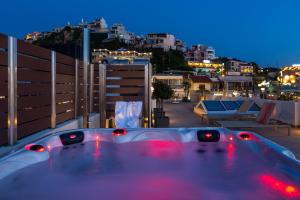 a bath tub sitting on top of a balcony at night at Angels Suites in Plataniás