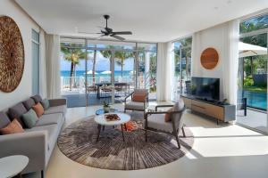 a living room with a couch and a tv at Premier Village Phu Quoc Resort Managed by Accor in Phu Quoc