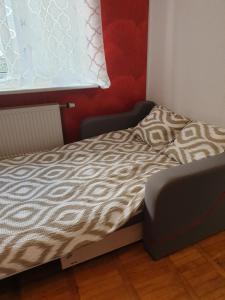 małe łóżko w pokoju z oknem w obiekcie Rose apartaments w mieście Lipawa