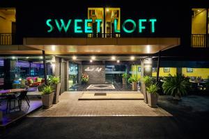 a night view of a restaurant with a sign that readssweet lift at Sweetloft Hotel Don Muang in Bangkok