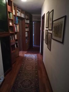 un corridoio con un tappeto su una parete con libreria di RELAX SANTA CHIARA a Bra