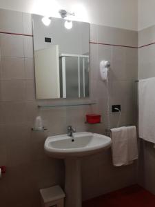 een badkamer met een wastafel, een spiegel en handdoeken bij Bellerive Ristorante Albergo in Manerba del Garda