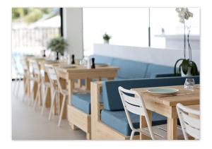 une rangée de tables et de chaises dans un restaurant dans l'établissement Hôtel Le Versailles, à Villefranche-sur-Mer