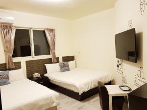 a hotel room with two beds and a tv at Especially chef's home B&B in Hualien City