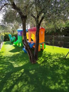 a childrens play set next to a tree at Campeggio Gianna Golfo dei Poeti in Lerici