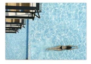 a person swimming in a swimming pool at Hôtel Le Versailles in Villefranche-sur-Mer