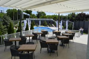 een terras met tafels en stoelen en een zwembad bij Road Star Hotel in Dnipro