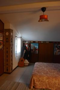 a bedroom with a bed and a guitar in it at Casa Mouramortina in Vila Nova de Poiares