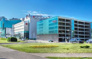 ein großes Gebäude mit davor geparkt in der Unterkunft Victoria & SPA Minsk in Minsk